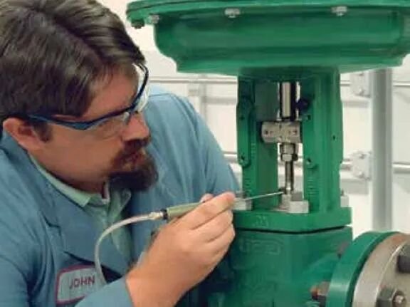 Technician performing EPA Method 21 leak detection on Fisher control valve with ENVIRO-SEAL live-loaded packing system, demonstrating low emission sealing technology for industrial applications