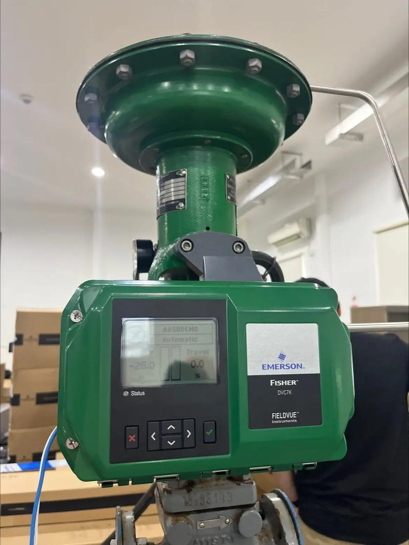 Genuine Fisher FIELDVUE DVC7K digital valve controller mounted on control valve, featuring LCD display with valve position feedback, pushbutton interface, and Emerson branding. SIL 2 certified smart positioner for industrial process control.